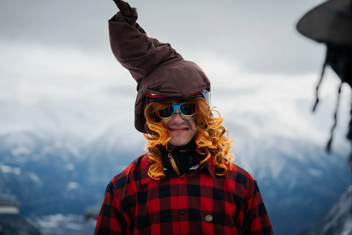 Porträt eines Teilnehmers mit Hexenhut, orangen Locken und bunter Sonnenbrille