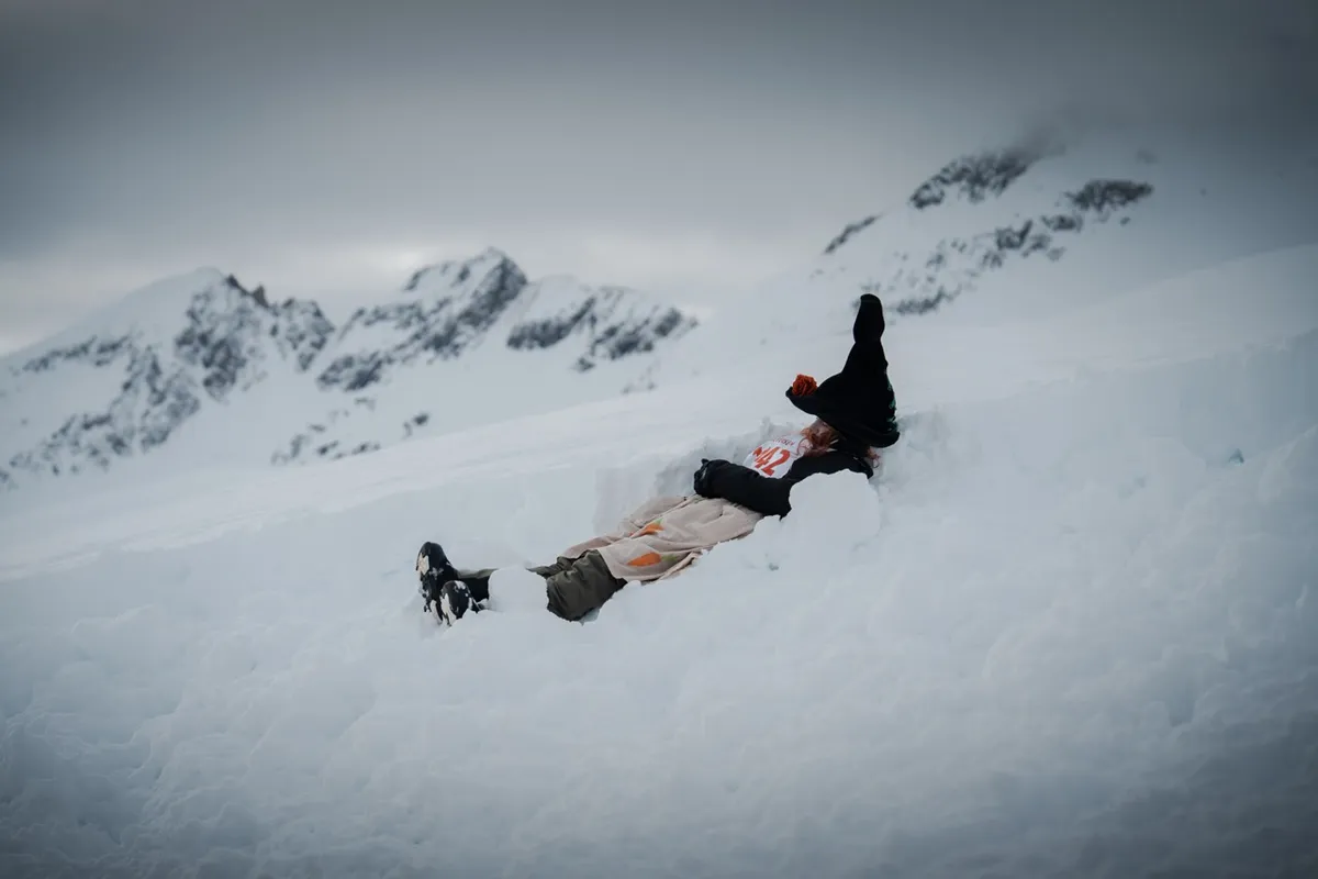 Kurze Pause: Teilnehmerin im Hexenkostüm liegt im Schnee