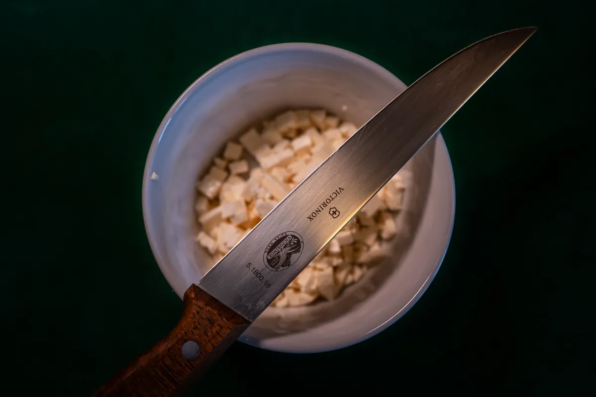 Messer liegt über einem Schälchen mit Fetawürfeln