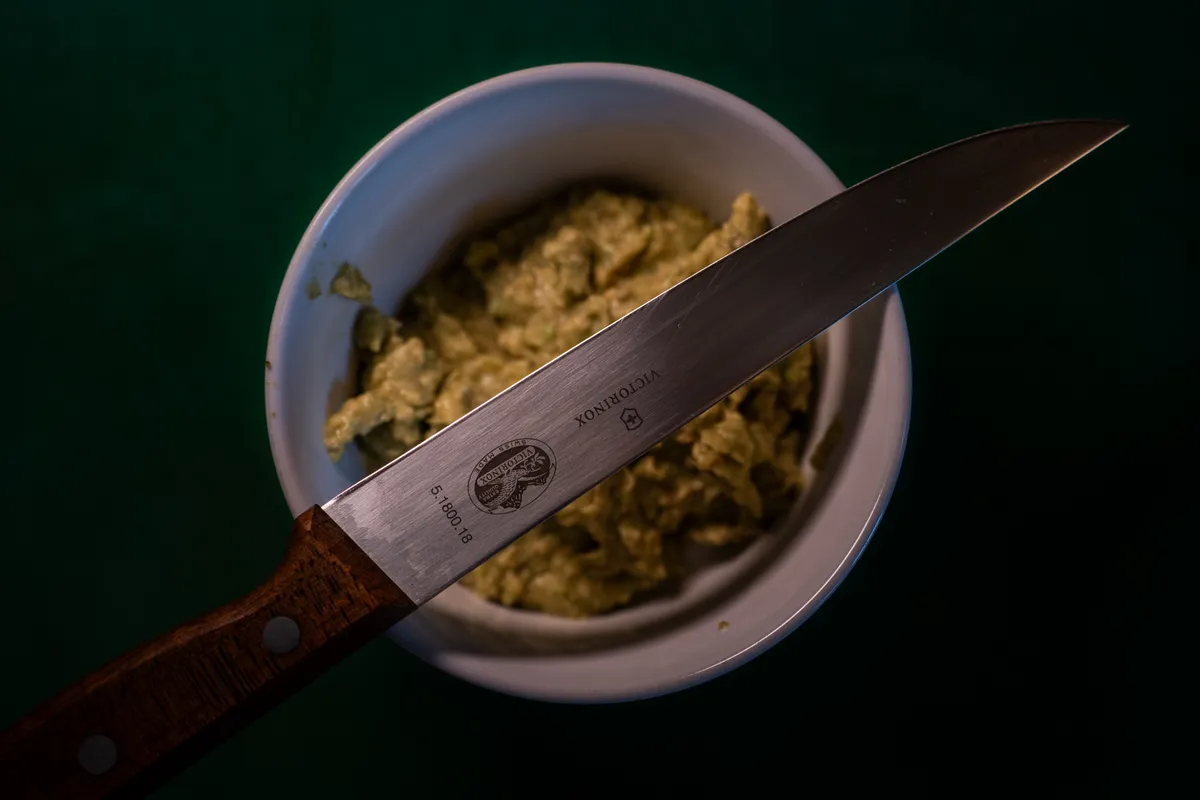 Messer liegt über einem Schälchen mit Avocadocreme