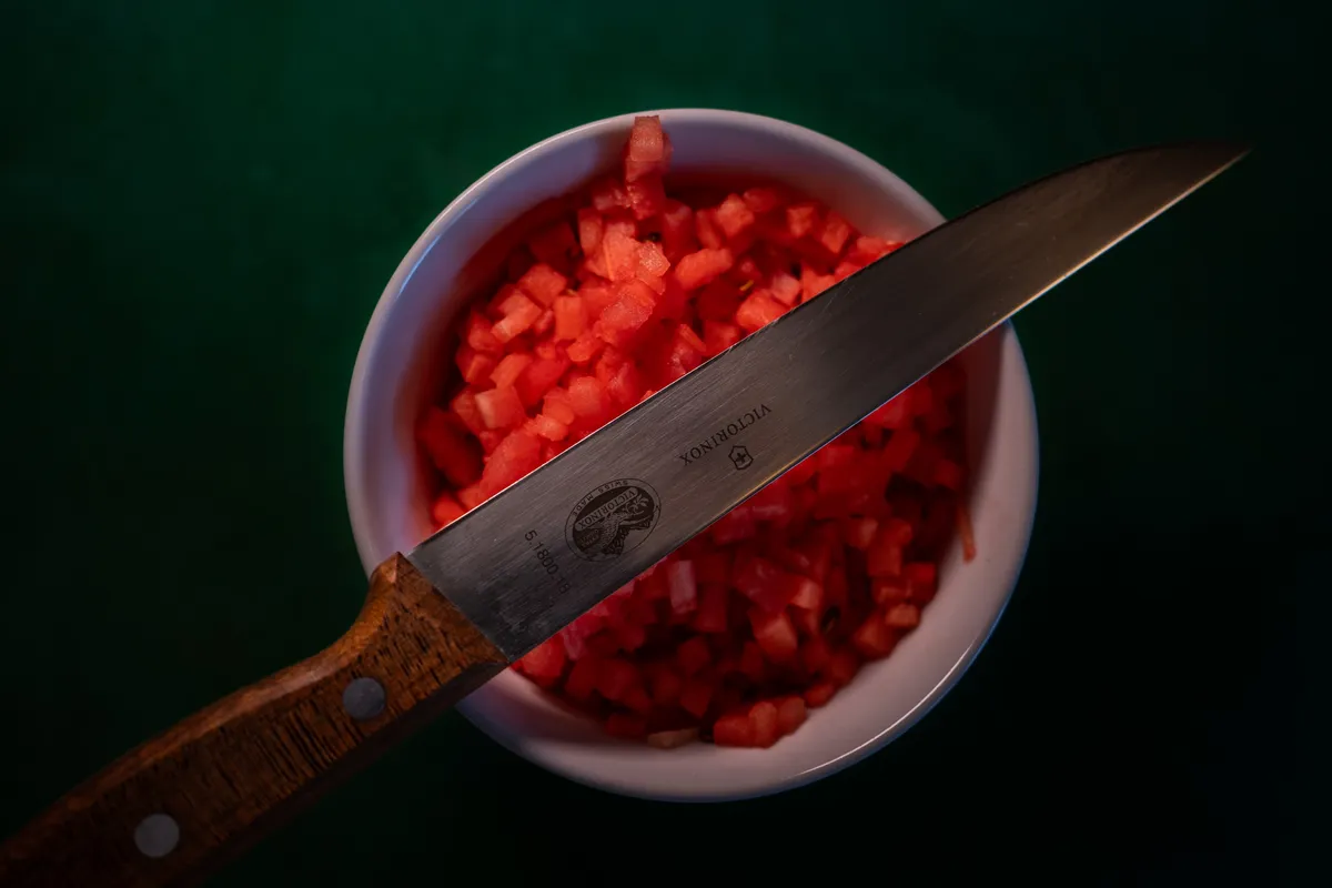 Messer liegt über einem Schälchen mit gewürfelter Wassermelone