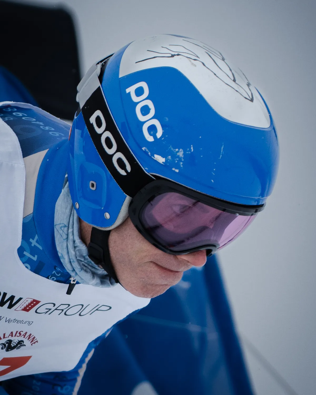 Nahaufnahme eines Rennläufers mit blauem Helm, der Blick gesenkt
