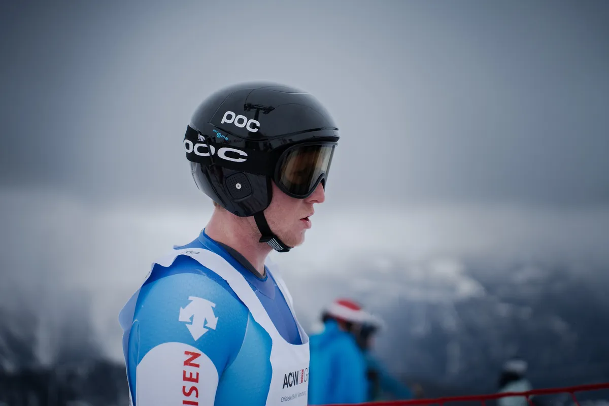 Rennläufer mit schwarzem Helm wartet konzentriert am Start
