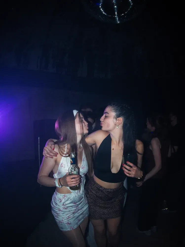 Zwei Gäste im Publikum unter einer Discokugel, violettes Licht