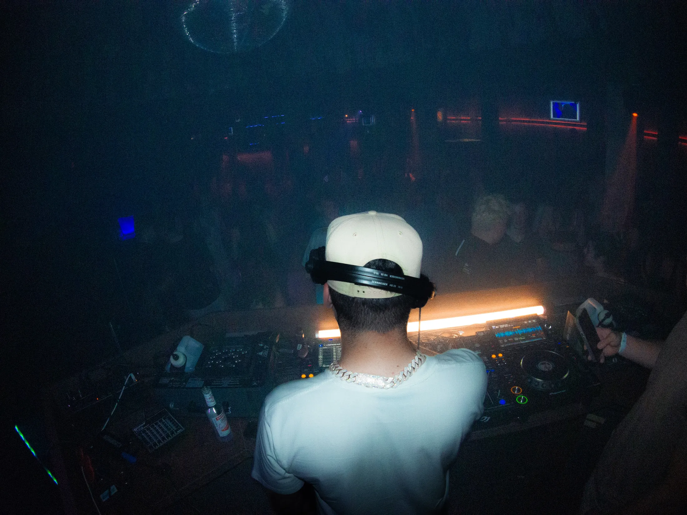 DJ Pereira am Mischpult im Loft Thun, farbiges Bühnenlicht