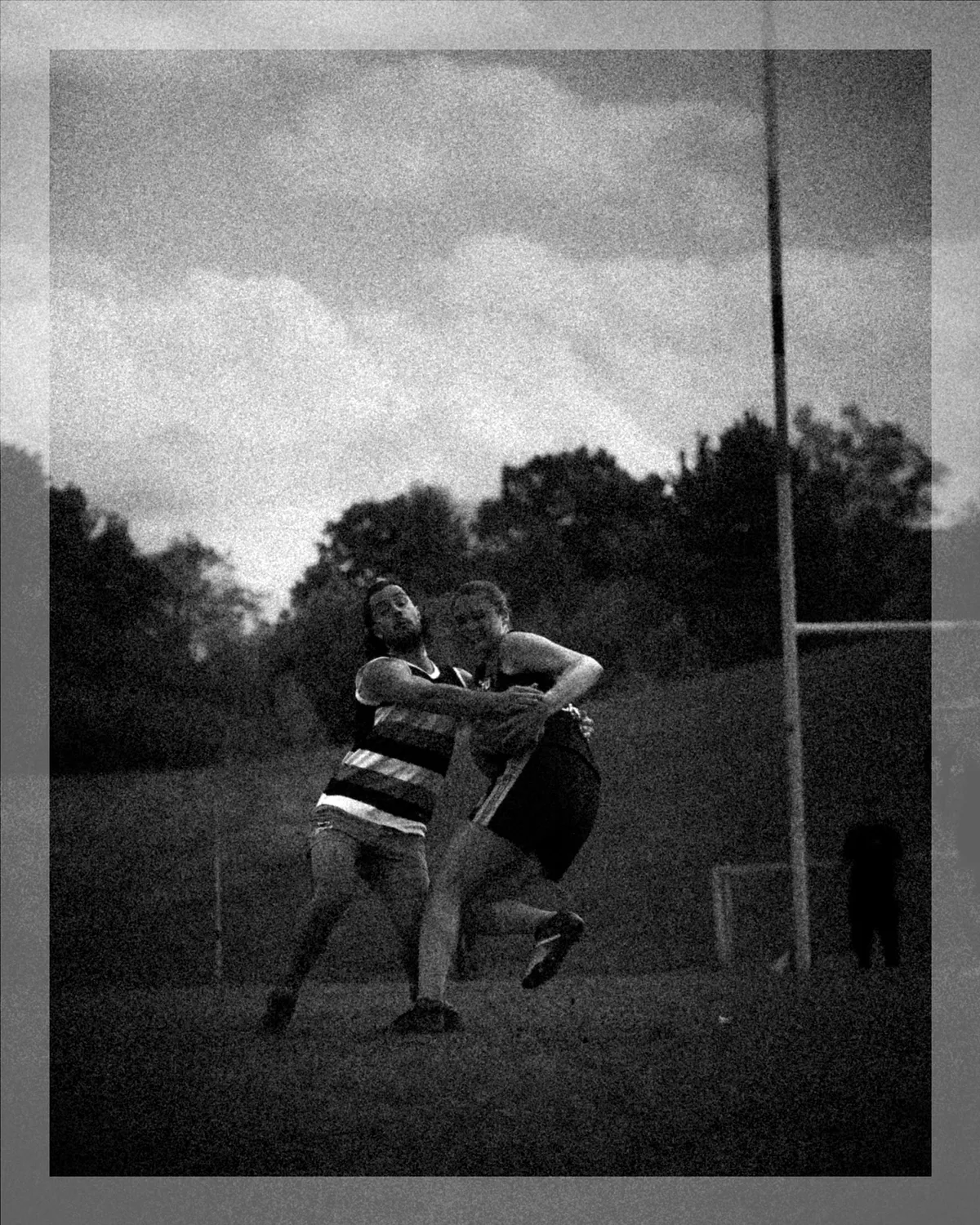 Schwarzweiss mit Rahmen: Zwei Spieler im Zweikampf vor dem Goalpost